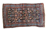 Antique Persian Kurdish tribal rug with Herati motif, dark navy field featuring floral and animal forms, red and blue borders, circa 1920s.