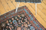 Tribal Herati pattern detail on an antique Kurdish rug corner with red and blue border.