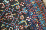 Geometric tribal Herati pattern with stylized motifs in navy, sky blue, madder red on antique Kurdish rug.