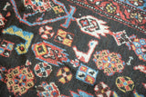 Abstract bird motifs in madder red, sky blue, saffron on an antique Kurdish rug.