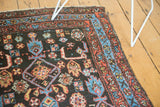 Antique Kurdish rug's corner with tribal Herati patterns, dark navy, madder red, sky blue.