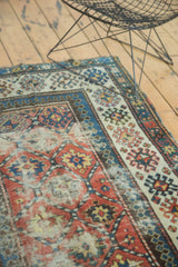 Geometric panel design in terra cotta, sky blue, and beige with aged patina on an antique Kazak rug.