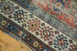 Hand-knotted geometric panel in terra cotta, sky blue, and ivory with striped border.