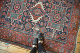 Karaja rug's central triple medallion in geometric Heriz style; navy, brick, mallard.