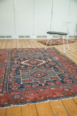 Antique Karaja rug's geometric floral pattern in navy, mallard green, and brick red.
