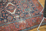 Worn Antique Karaja rug corner, geometric floral patterns in navy, red, teal, and ivory.