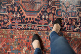 Vintage Karaja rug with navy, madder red, teal rectilinear floral motifs, tendrils, and wear.
