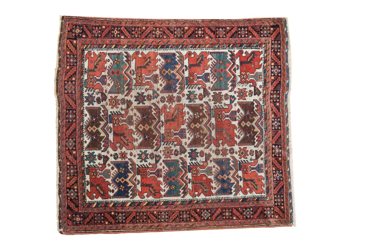 Antique Afshar square rug with an allover repeating bird motif in red, blue, and brown on an ivory ground.