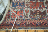 Corner of an antique Afshar rug featuring repeating bird motifs and intricate geometric borders.
