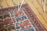 Corner view of the antique Afshar rug's 'barber pole' inner border and stylized bird motifs.