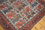Corner detail on an antique Persian Afshar rug with its geometric bird motifs and barber pole border.