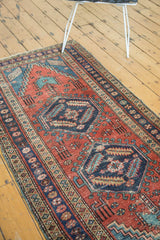 Antique Heriz runner detail: navy octagonal medallion, serrated leaves, geometric animals, madder red field.