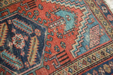 Madder red field with intricate floral cross-sections and navy blue geometric motifs.
