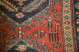 Antique Heriz runner's madder red field with intricate motifs, navy accents, and light foundation wear.