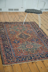Vintage Karaja rug corner with madder red field, geometric patterns, navy border, and light tatter.