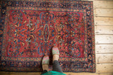 Cochineal red field of a vintage Lilihan rug with sprawling blue palmettes and tendrils.