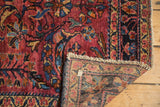 Vintage Lilihan rug with cochineal red floral field, fringed end, hand-knotted foundation.
