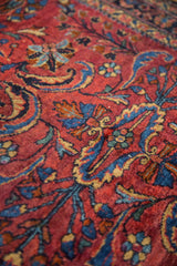 Dramatic red, navy, and gold sprawling floral motifs on a vintage Lilihan rug.
