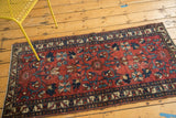Vintage Lilihan runner's wine red field with teal floral cross-sections and pile recess.