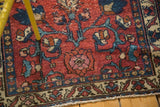 Wine red field of a vintage Lilihan runner featuring teal lotus flowers and a decorative border.