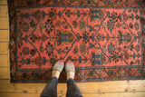 Blush Lilihan rug with ornate tree of life motif, sky blue patterns, a pair of feet.