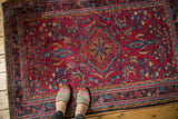 Vintage Persian Lilihan rug's scalloped medallion, raspberry field, and sprawling floral motifs.