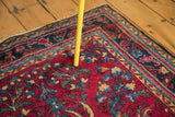Vintage Persian Lilihan rug corner: raspberry red, navy, gold floral motifs.