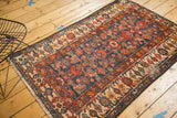 Fringed corner of vintage Malayer rug, with ivory patterned border and bound selvage.