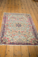 Corner of Vintage Kerman rug, featuring cochineal red rose bouquets and navy floral border.