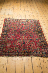 Corner detail of vintage Lilihan rug, showing cherry red field with intricate Sarouk floral motifs.