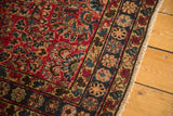 Cherry red Sarouk-style floral field, navy border with pale gold motifs, vintage Lilihan rug.