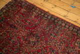 Vintage Lilihan rug corner with cherry red field, navy border, and sarouk-style floral bouquets.