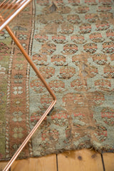 Open holes and faded mir boteh design on a distressed antique Kurdish rug fragment.