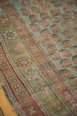 Distressed antique Kurdish fragment's detailed mir boteh and floral border in muted blue, sage, and rose.