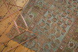 Distressed antique Kurdish rug fragment showing threadbare pile, holes, and muted colors.