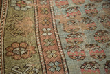 Distressed antique Kurdish rug fragment close-up, revealing threadbare texture and muted mir boteh motifs.