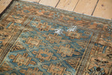 Distressed antique Belouch rug with sapphire blue geometric guls and distinct hand repairs.
