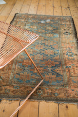 Aged perimeter and texture of the antique distressed Belouch rug with sapphire and copper tones.
