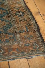 Distressed edge of the antique Belouch rug with geometric guls in sapphire blue.