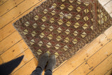 Antique Belouch prayer rug with geometric brown, yellow, and ivory pattern; visible mending.