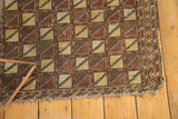 Antique Belouch prayer rug geometric lattice pattern in saffron and brown with blanket stitch edge.