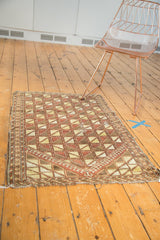 Antique Belouch prayer rug showcasing geometric lattice, saffron, brown, ivory palette, with storied perimeter.