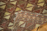Antique Belouch rug corner showing soft wool, geometric lattice pattern, and overcast blanket stitch.