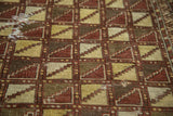 Antique Belouch rug's geometric lattice pattern in saffron, brown, ivory, with subtle mending.