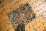 Antique Jalili Tabriz rug corner with dusty rust medallion, charcoal border, and fabric-banded edge.