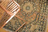 Close-up of antique Jalili Tabriz rug's fabric-wrapped side and intricate charcoal and rust border.