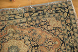 Antique Persian Jalili Tabriz rug side with protective grey fabric banding and white stitches.