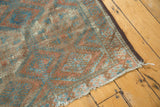 Tattered side cord selvage and secured end of a distressed Belouch rug runner.