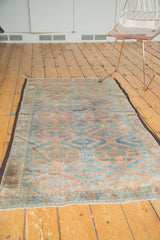 Distressed Belouch runner featuring oversized gul motifs in soft terra cotta and sky blue.