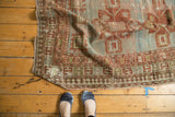Distressed geometric border on antique Caucasian rug with faded powder blue and terra cotta.